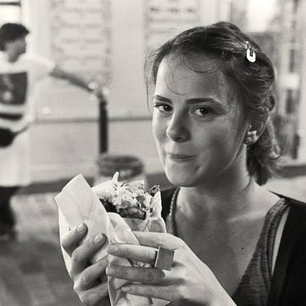 Black and white Mariana Acevedo holding a sandwich